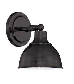 The Timarron - 35901, part of the Timarron collection, is a wall-mounted sconce that embodies industrial chic with its round backplate and hammered dark-finished metal shade. Its simple curved arm gracefully connects the two, offering both functionality a