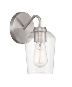 The Shayna - 56101 features a brushed nickel finish and clear glass shade, highlighting an exposed vintage-style filament bulb. Its curved metal arm extends from a round wall mount, seamlessly integrating pendant and industrial design elements for a moder
