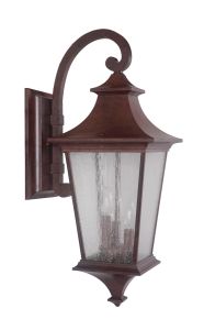 The Argent - Z1374 is a rustic outdoor wall lantern with a vintage brown metal finish, featuring a curved arm and clear seeded glass panels encasing the bulb holder, mounted on a rectangular backplate.