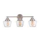 The Essex - 19528 from Craftmade is a three-light wall sconce with a brushed nickel finish, featuring clear glass schoolhouse globes, exposed filament bulbs, and an elegant oval backplate.
